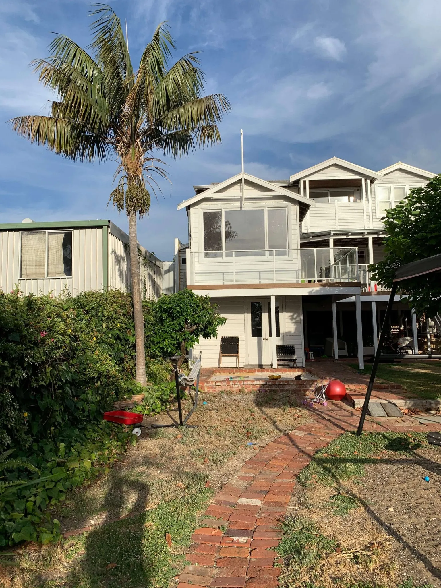 Overgrown Beaconsfield backyard in Perth before landscape makeover, showing tired lawn and old features.