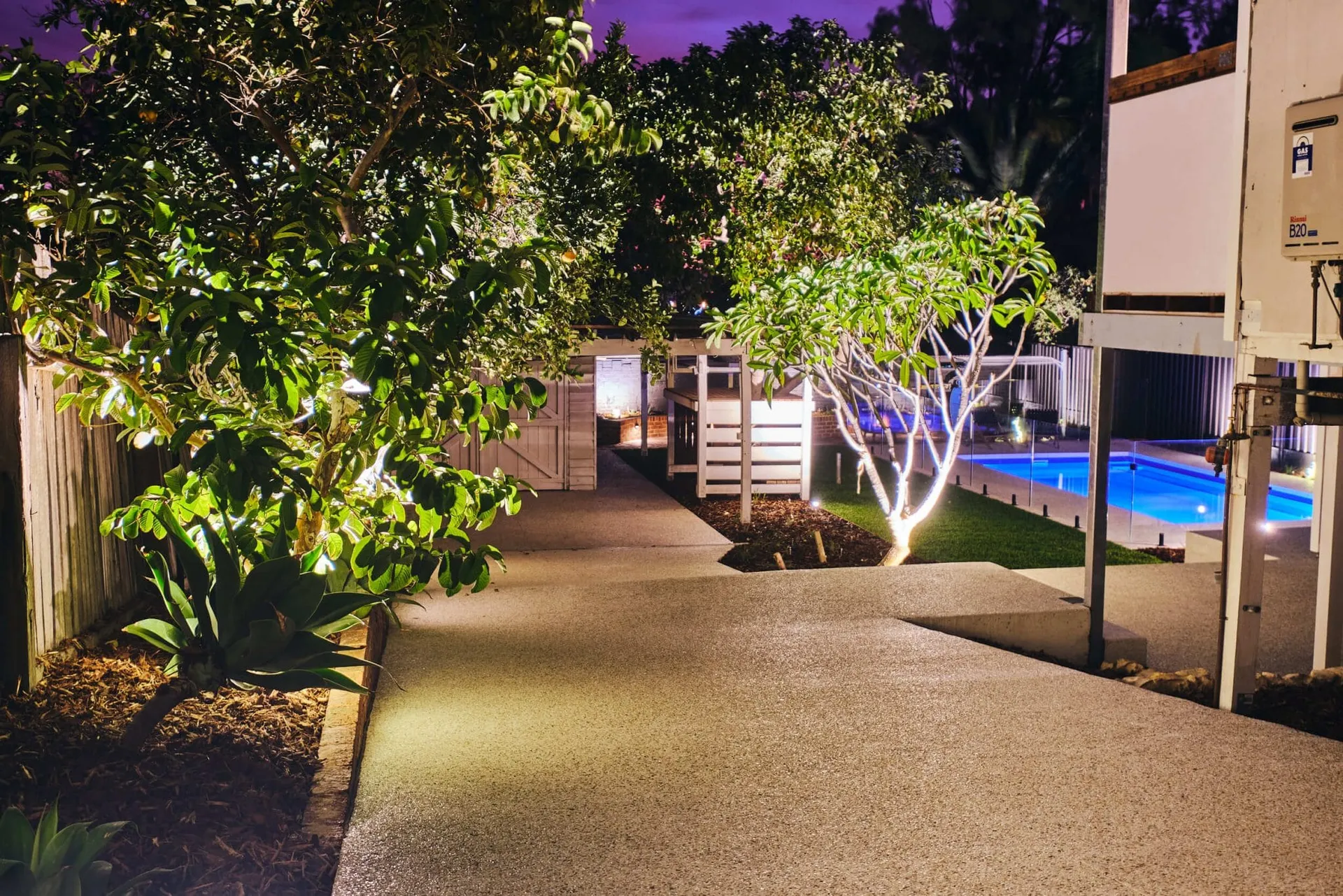 Exposed aggregate pathway winding through the new Beaconsfield Perth backyard with garden bed plantings.