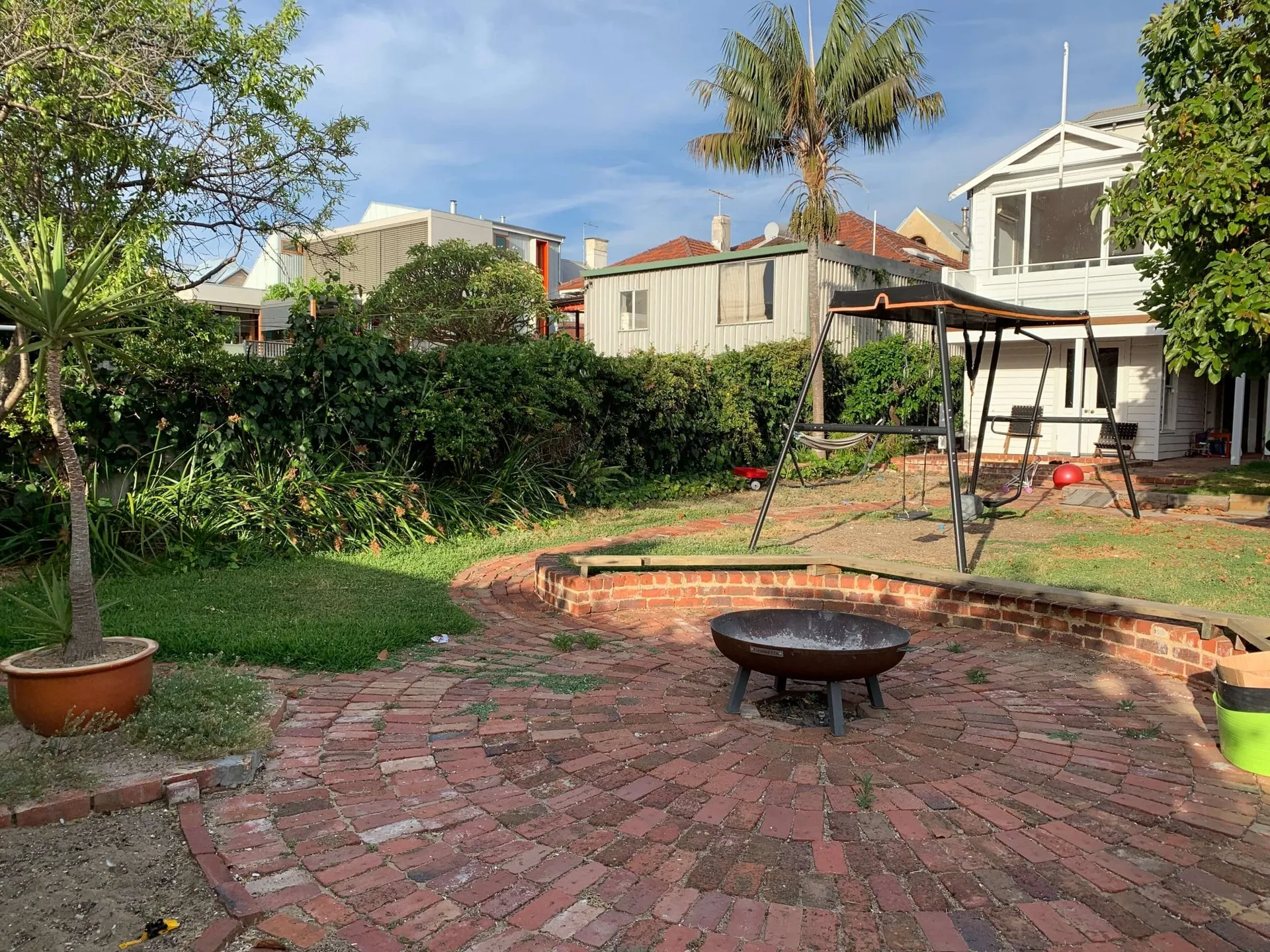 Old firepit and tired paving in the Beaconsfield Perth backyard before the landscape transformation.