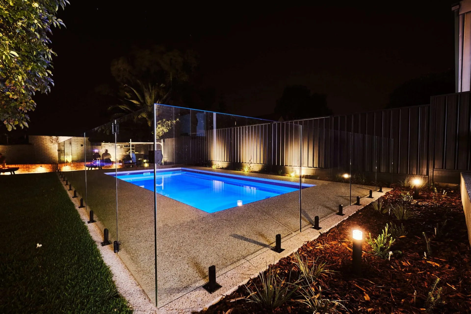 Landscape view of the finished Beaconsfield Perth backyard with pool, alfresco and lush garden beds.