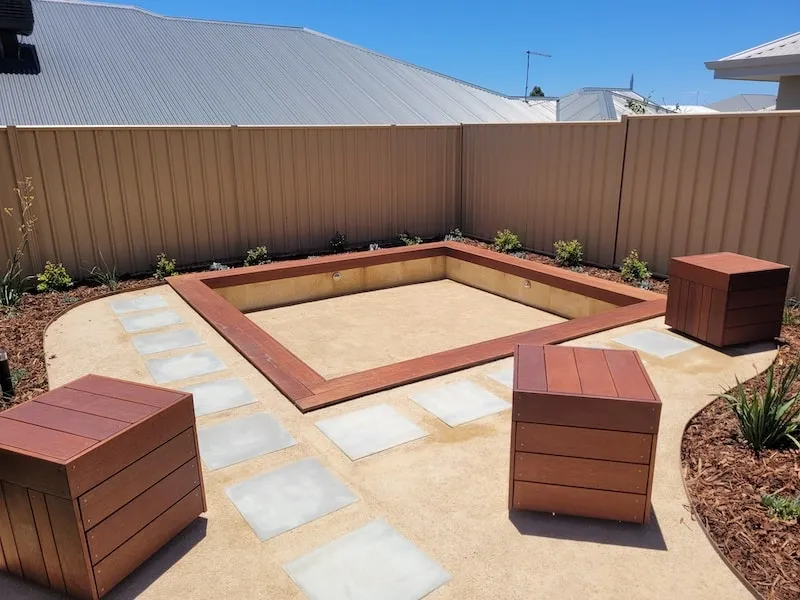 Custom backyard firepit and seating boxes built from reused decking at the Beeliar Perth project.