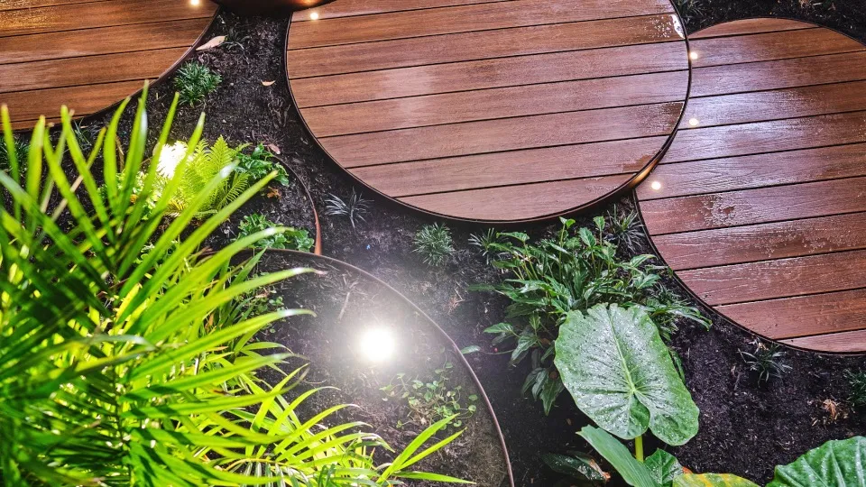 Hay Street Perth feature garden with corten steel deck pods and lush tropical planting at building entrance.