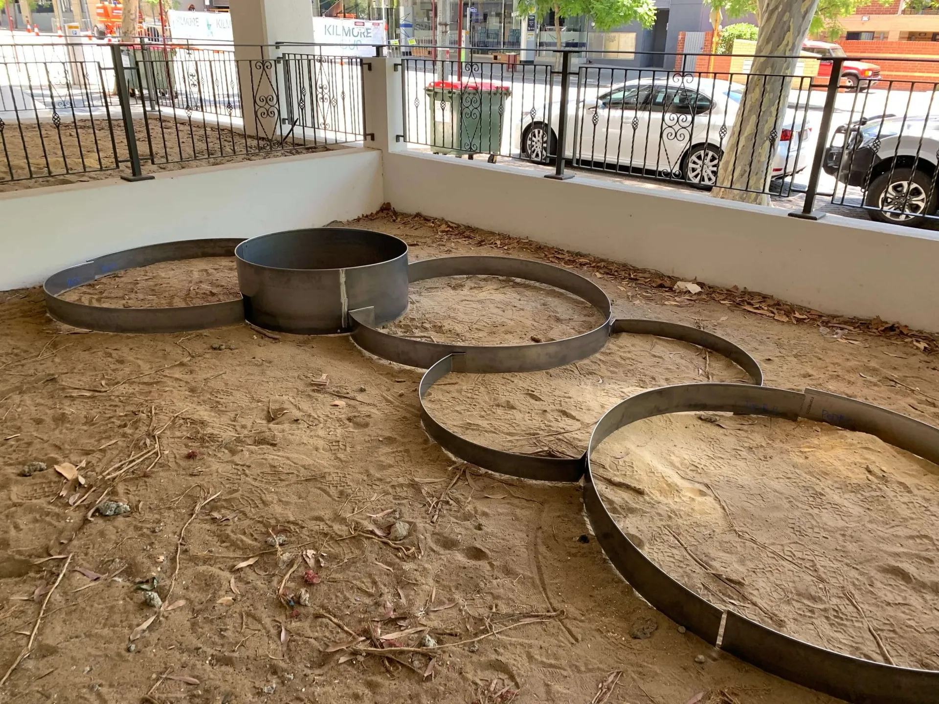 Landscaper laying out corten steel deck pods on the Hay Street Perth site during installation.