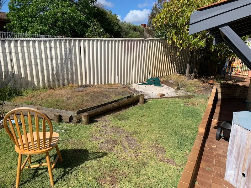 Side of the Leeming Perth house before landscaping, with bare ground and dated brick edging.