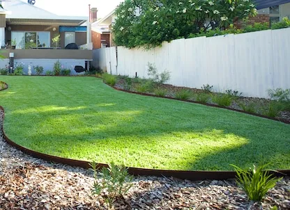 Natural turf installation in a backyards install in backyard curved lawn