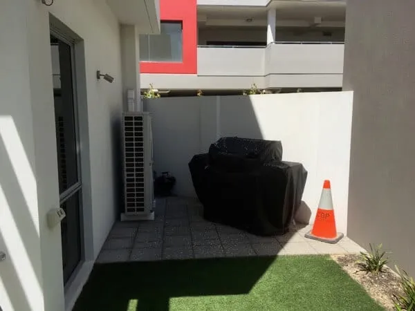 Bare corner of the South Perth courtyard before landscaping with cheap synthetic grass in place.