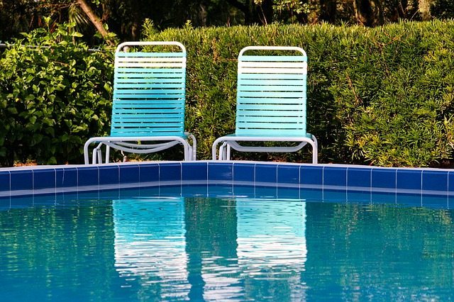 Choosing the Right Poolside Plants - Two chairs near blue pool