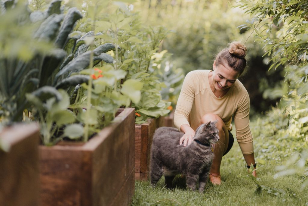 Woman gardener with cat in garden